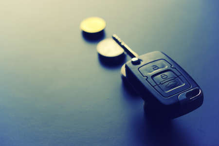Black keychain car key on a matt black background and moneyの写真素材