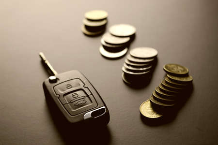 Black keychain car key on a matt black background and moneyの写真素材