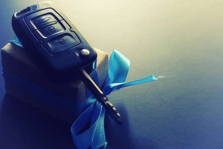 Black keychain car key on a matt black background and moneyの写真素材