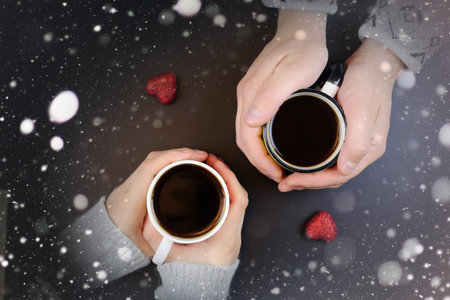 two lovers holding each other's hands and drinking coffee at the table