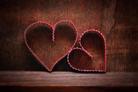 small red paper hearts on a background of brown wood textureの写真素材