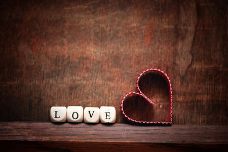 small red paper hearts on a background of brown wood textureの写真素材