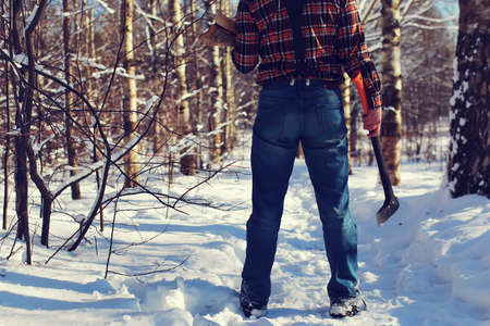 bearded handsome man went into the forest with an ax to produce wood for the furnaceの写真素材