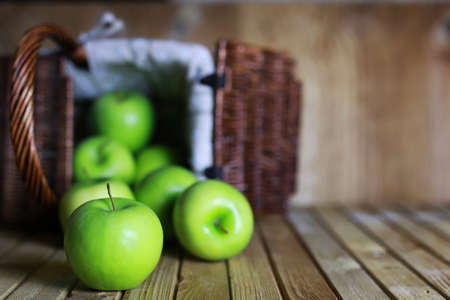 fresh green juicy apples in a basket on a wooden table rusticの写真素材