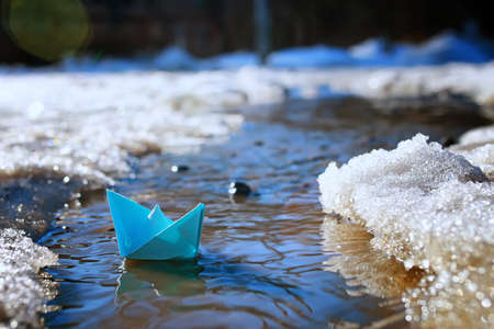 small paper folded boat origami method in a spring brook in the parkの写真素材