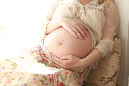 Pretty pregnant beautiful girl with white curly hairの写真素材