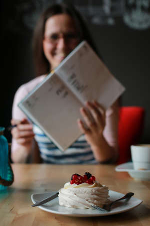 portrait of cute girl working on a laptop and drinking coffee in a cafeの写真素材