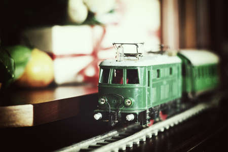 little old toy train on the track and with a motor under the Christmas tree decoratedの写真素材