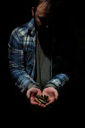 bullet in hands man on black isolated baclgroundの写真素材