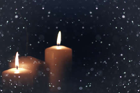 bright flame of a burning candle on a black background on the eve of New Year holidaysの写真素材