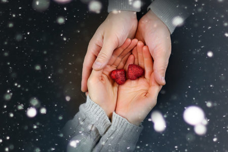 two lovers holding each other's hands and drinking coffee at the tableの写真素材