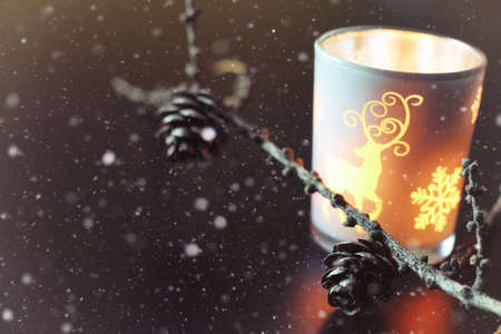 home decor on the table candle in a glass lamp and dry larch branchの写真素材