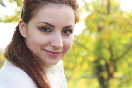 a pretty girl of European appearance in fashionable autumn clothing walking in the park