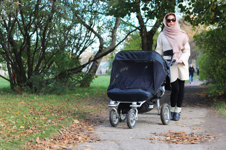 a pretty girl of European appearance in fashionable autumn clothing walking in the parkの写真素材