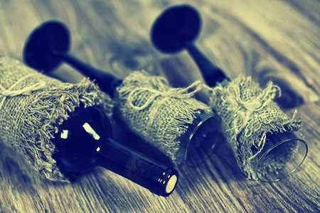 Decorated bottle of fine wine on a wooden table with glassの写真素材