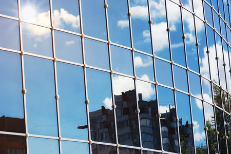background glass office building windows with reflection of sky in themの写真素材