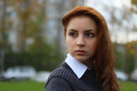 pretty young woman posing on camera in autumn parkの写真素材