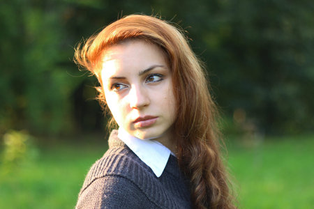 pretty young woman posing on camera in autumn parkの写真素材