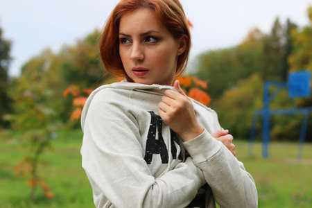 Pretty cute young girl walking in golden autumn parkの写真素材