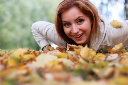 Pretty cute young girl walking in golden autumn park