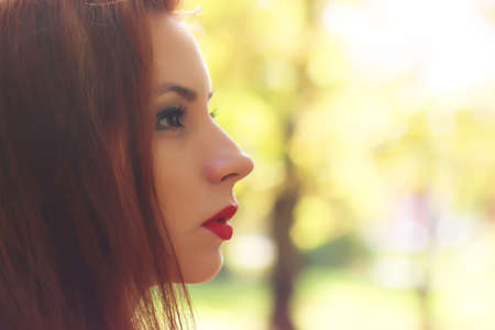 Pretty cute young girl walking in golden autumn parkの写真素材