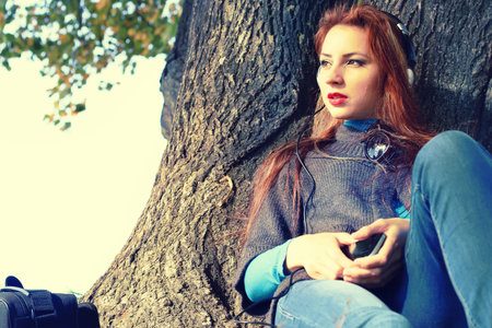 Pretty cute young girl walking in golden autumn park