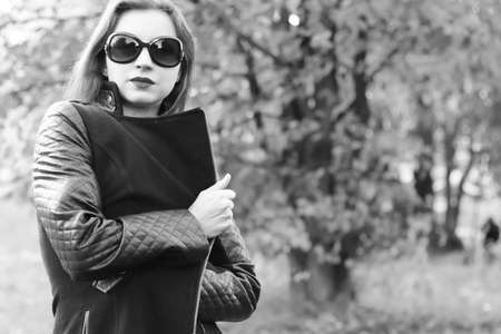 Pretty cute young girl walking in golden autumn parkの写真素材