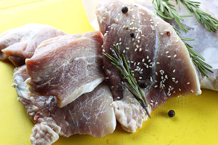 big piece of fresh raw pork meat with seasonings of salt and pepper on the tableの写真素材