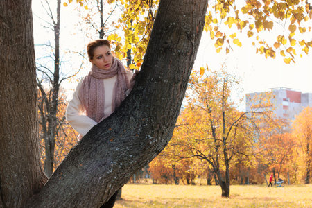 a pretty girl of European appearance in fashionable autumn clothing walking in the parkの写真素材