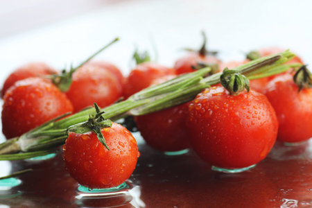 Fresh juicy small fragrant red cherry tomatoes in the backgroundの写真素材