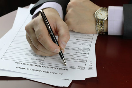 male hand in a business suit holding a pen and preparing to sign a contract