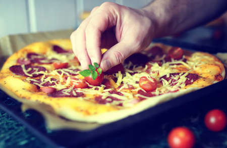 dough for pizza with cherry tomatoes and basil smoked sausageの写真素材