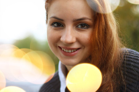 pretty young woman posing on camera in autumn parkの写真素材