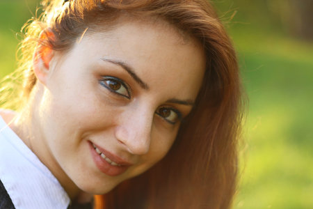pretty young woman posing on camera in autumn park