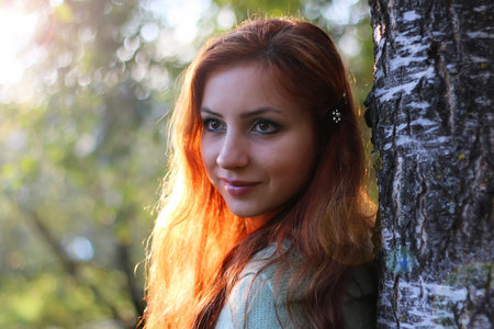 pretty young woman posing on camera in autumn park