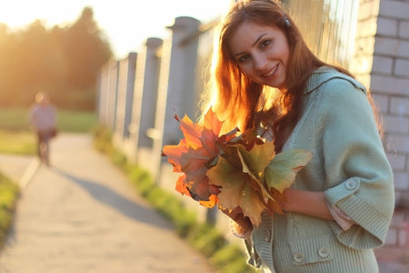pretty young woman posing on camera in autumn parkの写真素材