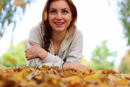 Pretty cute young girl walking in golden autumn parkの写真素材