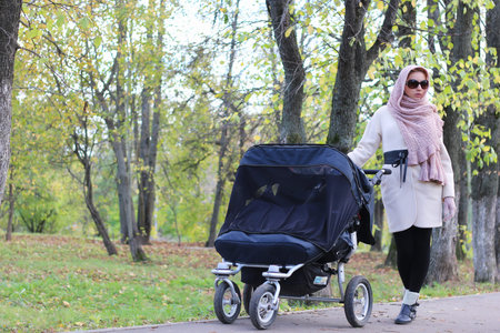 a pretty girl of European appearance in fashionable autumn clothing walking in the park