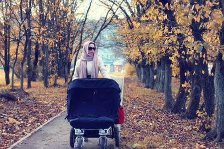 a pretty girl of European appearance in fashionable autumn clothing walking in the parkの写真素材