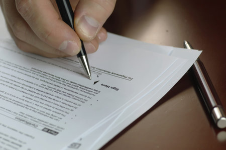 male hand in a business suit holding a pen and preparing to sign a contract