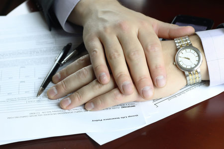 male hand in a business suit holding a pen and preparing to sign a contract