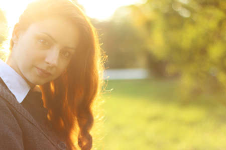 pretty young woman posing on camera in autumn parkの写真素材