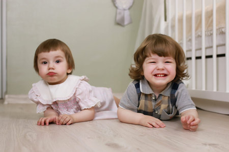 cute little kids on the floor in the interior of a child's roomの写真素材