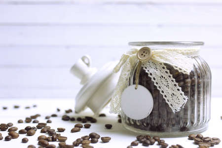 coffee beans on a white wooden background in bulk and in a glass jarの写真素材