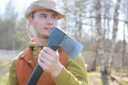 man outdoor with axe in village in spring season