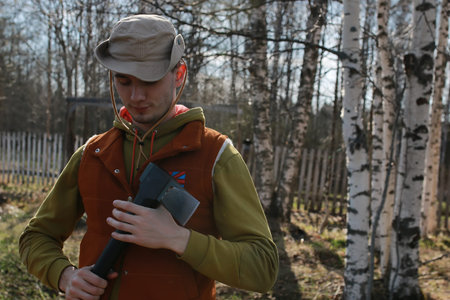 man outdoor with axe in village in spring seasonの写真素材