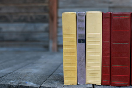 books standing different objects on a wooden table on a background of blurred summer foliageの写真素材
