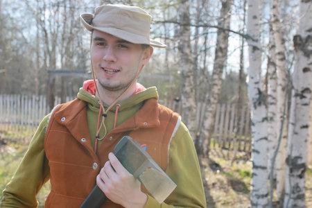 man outdoor with axe in village in spring season
