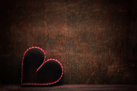 small red paper hearts on a background of brown wood textureの写真素材