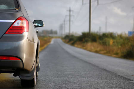 car on country road lane in rainy autumn dayの写真素材